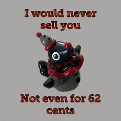 a black and red stuffed animal sitting on top of a white table next to a sign that says, i would never sell you not even for 64 cents