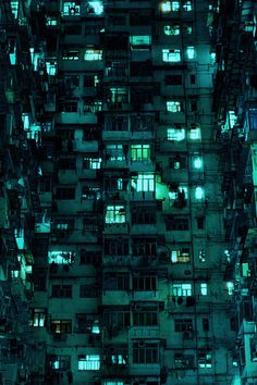 an aerial view of many apartment buildings at night with green lights on the windows and balconies