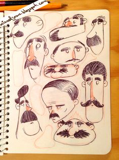 a notebook with drawings of men's faces and mustaches on it next to a pencil