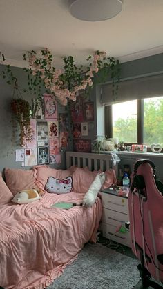 a bedroom with pink bedding and flowers hanging from the ceiling