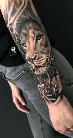 a man's arm with a lion and roses tattoo on the left side of his arm