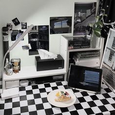 a laptop computer sitting on top of a desk next to a plate with fruit on it