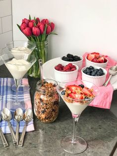 a table topped with desserts and fruit on top of each other next to bowls of cereal