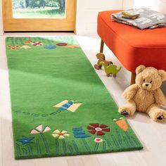 a teddy bear sitting on the floor next to a green rug