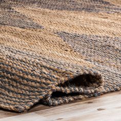 a close up of a rug on the floor with a wooden floor in the background