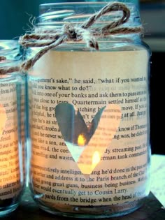 two jars filled with candles sitting on top of a table