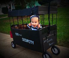 a baby in a security wagon on the sidewalk