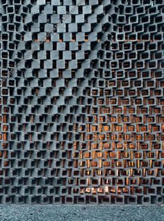 a close up view of a metal grate with orange light reflecting on it's surface