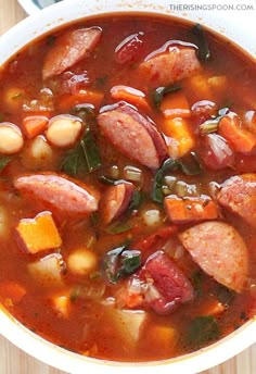 a white bowl filled with sausage and bean soup