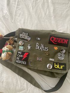 decorated messanger bag #thebeatles #blur #davidbowie #frankocean #lanadelrey #queen #themarauders #sexpistols #brooklyn99 #mischiefmanaged #gryffindor #harrypotterfan #universalstudiosjapan Cute Messenger Bag Aesthetic, Decorated Messenger Bag Aesthetic, Decorated Messenger Bag, School Bag With Pins, Messenger Bag Decoration, Messenger Bag Pins, Grunge Messenger Bag