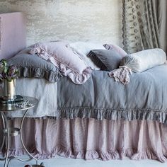 a bed with ruffled bedspread and pillows