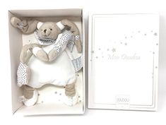 a stuffed animal in a white box with silver stars on it's head and chest