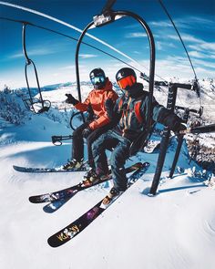 two skiers sitting on a ski lift in the snow