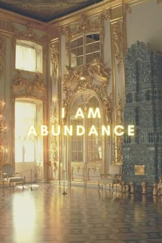 the words i am abundance are lit up in front of an ornate room with gold and white walls