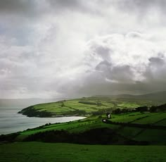 green fields and water under a cloudy sky