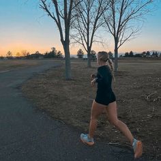 a woman running in the park at sunset