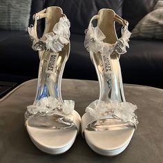 a pair of white high heels with flowers on them