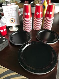 red and black paper plates with polka dots on them sitting on a table next to other party supplies