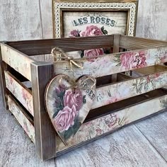 a wooden box with flowers painted on the sides and a heart in the middle, sitting on a wood floor