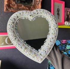 a heart shaped mirror hanging on the wall