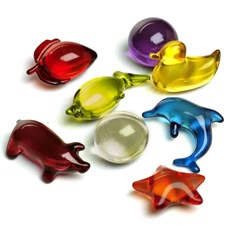 six different colored glass animals sitting on top of a white surface with one animal in the middle