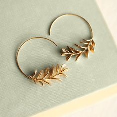 These rosemary leaf hoop earrings are made from solid brass with some amazing detail on the leaves.  They feature a detailed botanical sprig of leaves, in a rich golden brass tone.   The earwires are solid copper which provides an interesting contrast with the golden brass.   The hoop earrings measure 5cm (two inches) in diameter.   This piece of jewellery comes packaged in a nice recycled gift box with a handmade tag, all ready to give or keep. 🖤 FASTER SHIPPING 🖤 Need this fast? We offer a Faster Shipping option here: https://www.etsy.com/uk/listing/100107311/faster-shipping-priority-post-upgrade Please read the description before purchasing this listing, as we are unable to post every day! 🖤 GIFT MESSAGE & WRAP SERVICE! 🖤 For those of you who are sending gifts straight to your loved Gold Leaf-shaped Hoop Earrings For Gift, Gold Leaf Hoop Earrings, Nature Inspired Earrings, Woodland Earrings, Twig Branch, Branch Earrings, Earrings Nature, Hoop Earrings Gold, Ear Cuff Earings