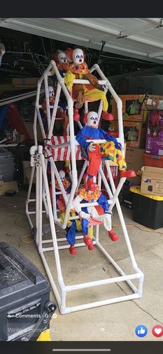 a ferris wheel with clowns on it in a garage next to other toys and tools