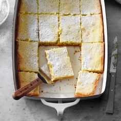 a pan filled with squares of cake next to a spatula