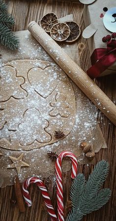 a cookie is sitting on a table next to some candy canes and christmas decorations