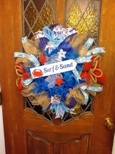 a door with a wreath on it that says surf and sand