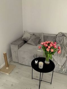 a living room with a couch, table and flowers