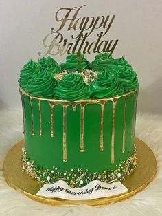 a birthday cake with green frosting and gold decorations