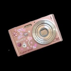 a pink digital camera sitting on top of a white surface