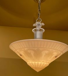 a chandelier hanging from the ceiling in a room with yellow walls and ceilings