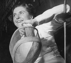 black and white photograph of a woman holding a tennis racket in her right hand