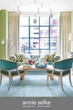 a living room filled with furniture next to a large window and blue carpeted floor