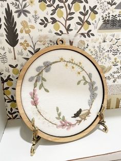 a white plate with flowers and birds on it next to a wallpapered background