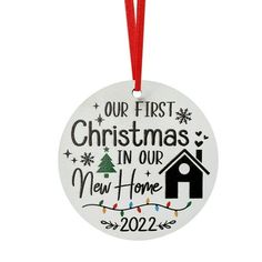 a christmas ornament hanging from a red ribbon with the words, our first christmas in