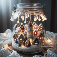 a crocheted christmas village in a glass jar