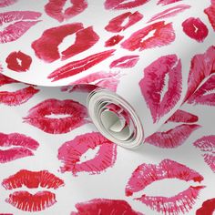 pink and red lipstick print on white fabric with silver rollers in the center,