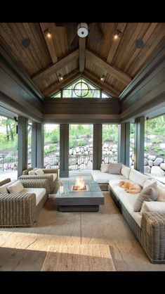 a living room filled with furniture and a fire place in the middle of an open floor plan