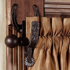 a pair of brown curtains hanging on the side of a wooden door with metal handles