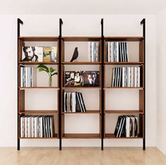 a book shelf filled with lots of books on top of a hard wood floor next to a white wall