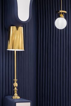 a lamp that is on top of a table in front of a blue wall with pleated curtains