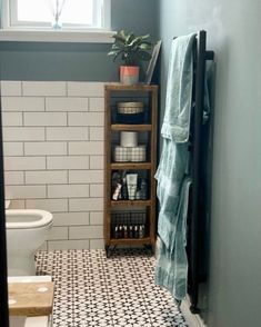 a white toilet sitting next to a bath tub in a bathroom under a window with blue walls