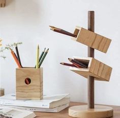 there is a wooden holder with pencils in it on the table next to books