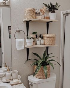 a white toilet sitting in a bathroom next to a sink and a bath room mirror