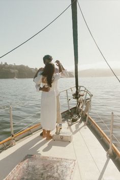 a woman standing on the bow of a boat