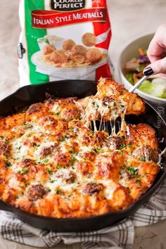 a person is taking a piece of pizza out of the casserole dish with a fork