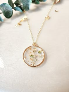 a necklace with flowers in it sitting on top of a table